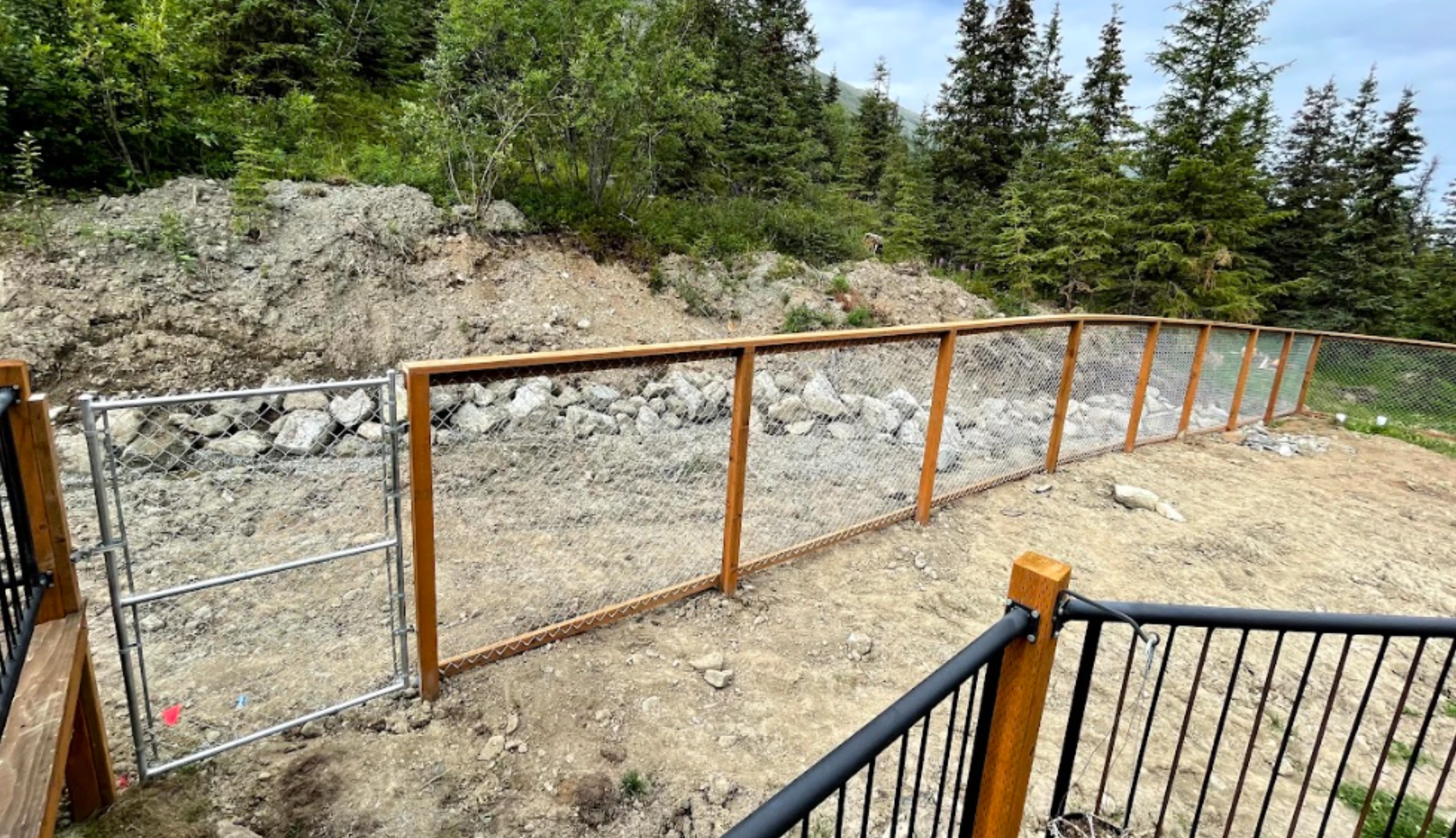 California-style chain link fence on Alaska hillside with cedar uprights